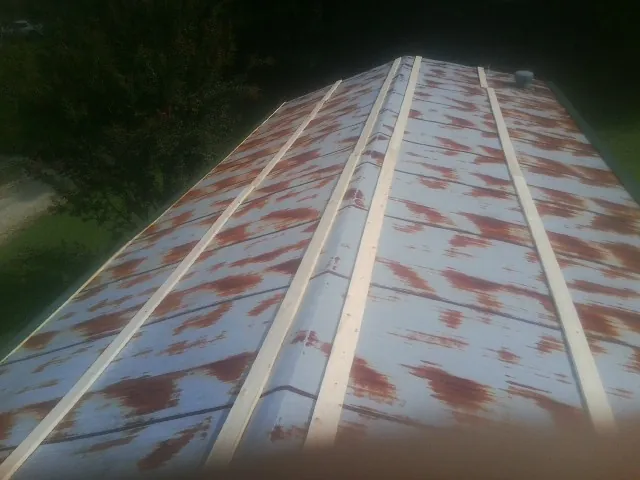 Rusted metal roof panels with new wood purlins before replacement — Storm Damage Roof Repair in Hankinson by Roofing Brothers