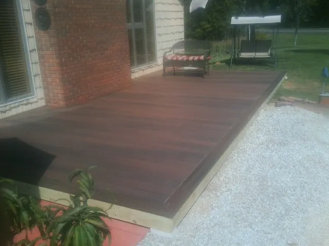 Freshly stained wood deck built against a brick home in Hankinson